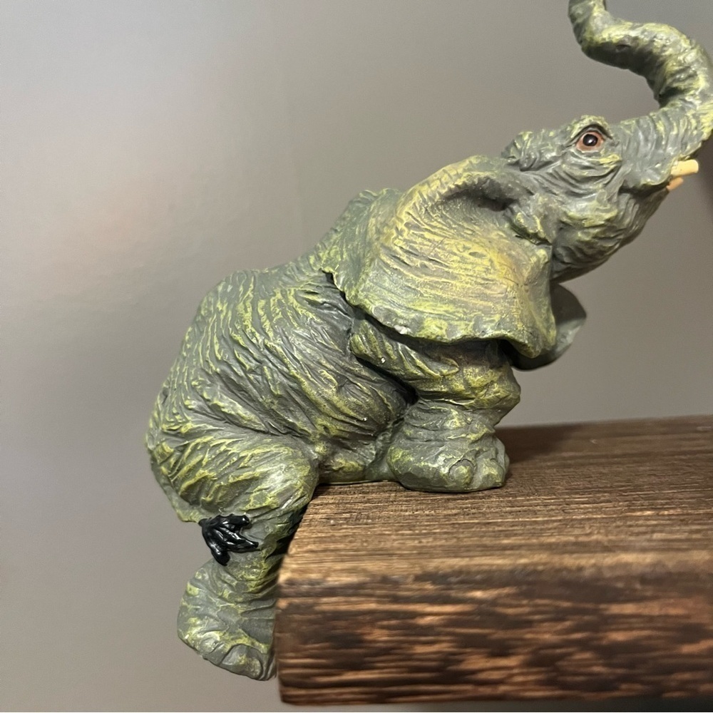 Elephant figurine made in China. Looks like he is trying to climb up onto a step